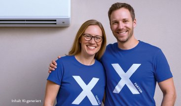 Zwei Personen mit einem X auf blauen Shirts stehen vor einem Klimagerät