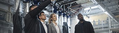 Vier Personen im Heizungskeller sprechen über die Heizungsinstallation